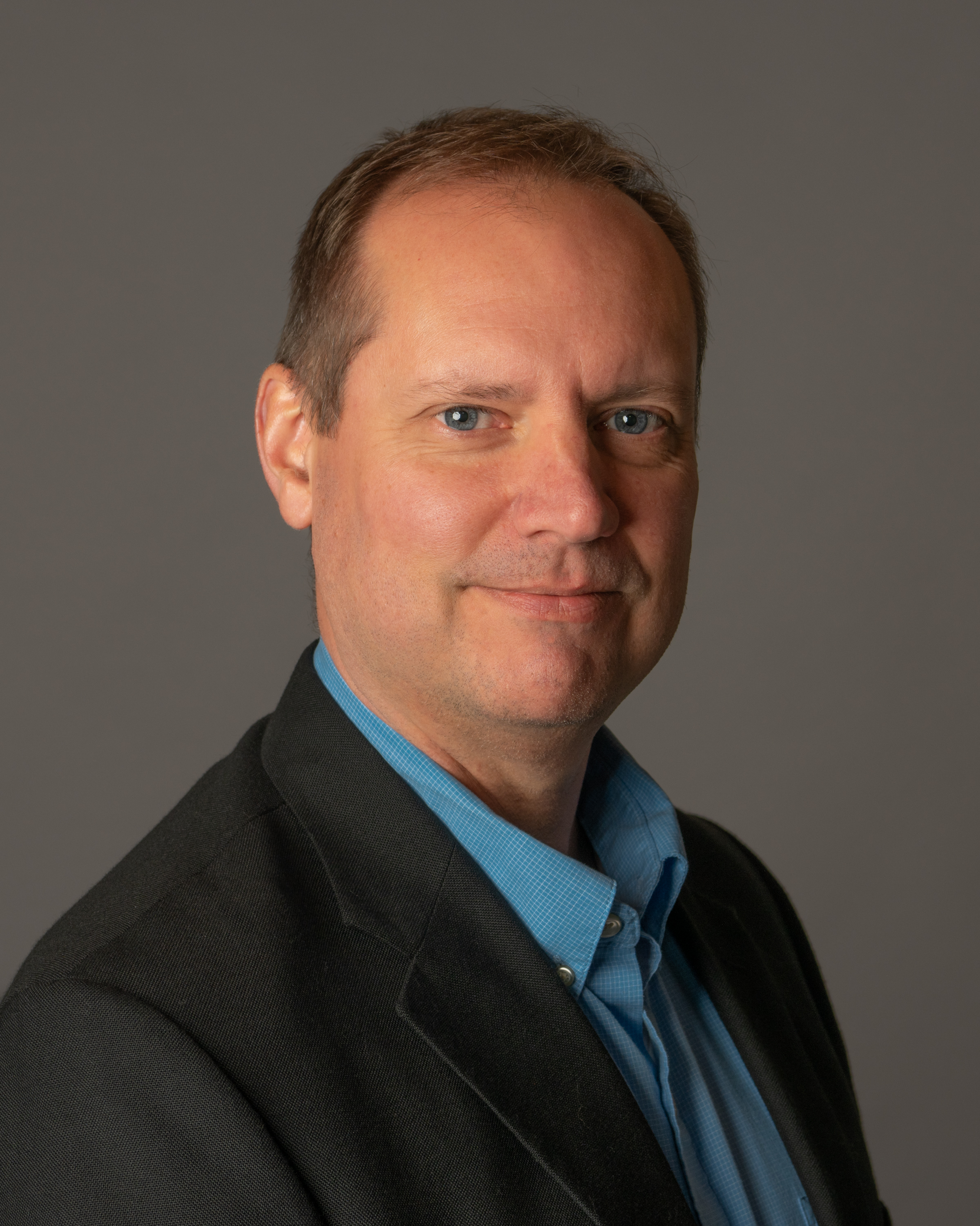 Man in a button down shirt and sport coat