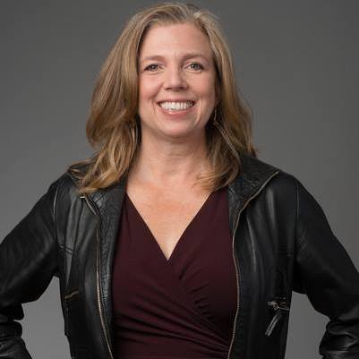 a smiling woman wearing a leather jacket 